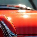 Close up view of a clean, shiny car surface reflecting sunlight.